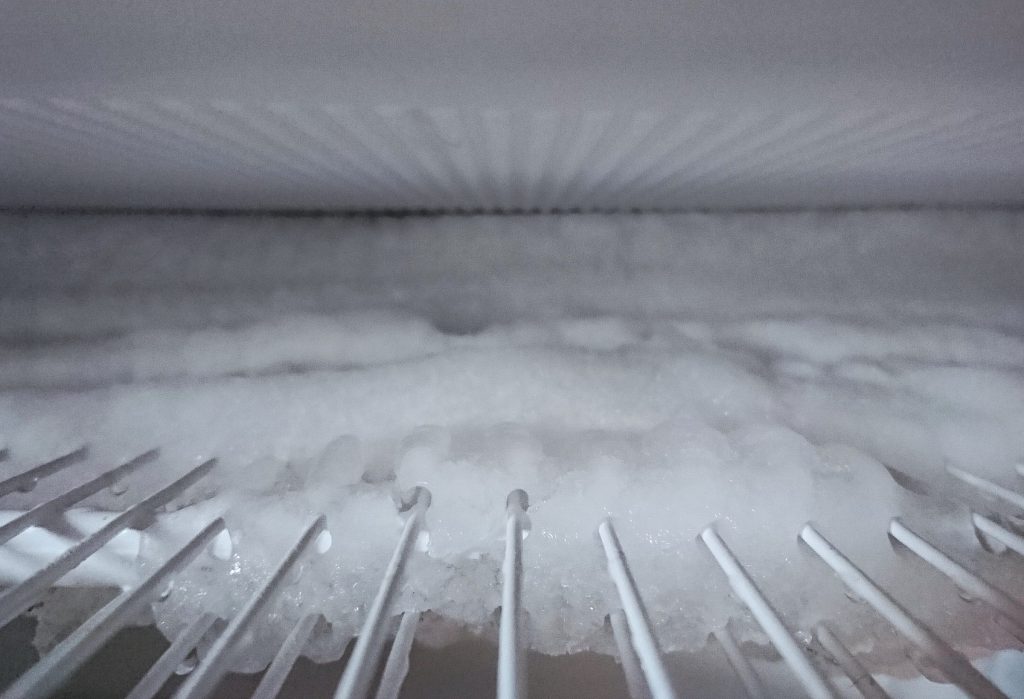 A frosted evaporator coil, which is what a failed defrost system looks like