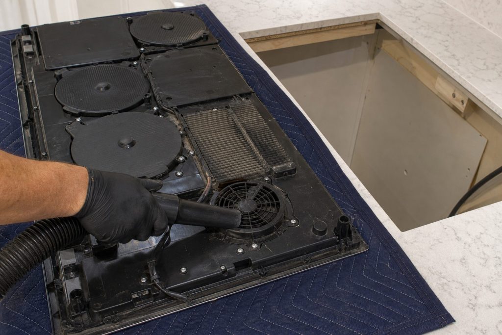 An induction cooktop with its coils and board exposed